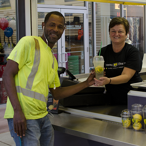Lemon Heaven server handing lemonade to mall worker